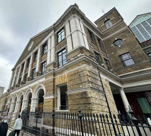 A building with a quote overlay that says 'We have made a good start but there is much more to do.'